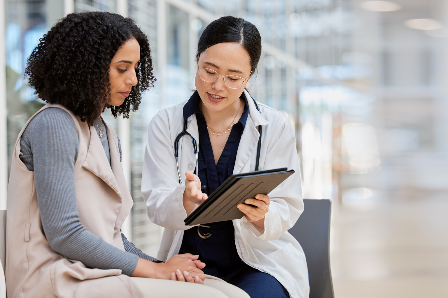 Doctor with tablet speaking to female patient.